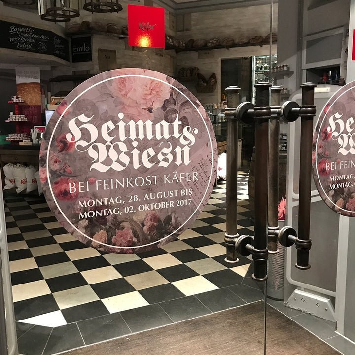 Runder Fensteraufkleber an Glastür in einem Feinkostgeschäft